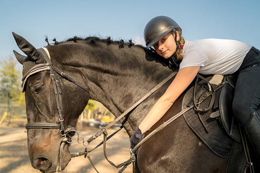 Portrait of teenage girl with horse in stable