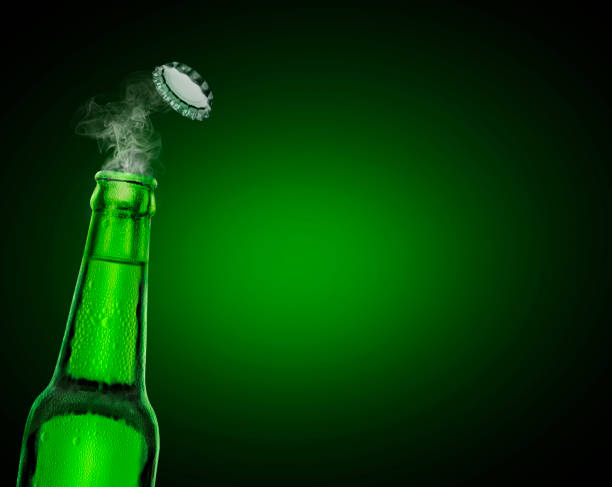 kalte nasse offene bierflasche mit rauch auf grünem hintergrund - green beer fotos stock-fotos und bilder
