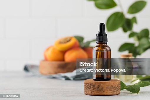 istock Glass dropper with skin serum with apricot seed extract. Cosmetics with natural ingredients. 1411208157