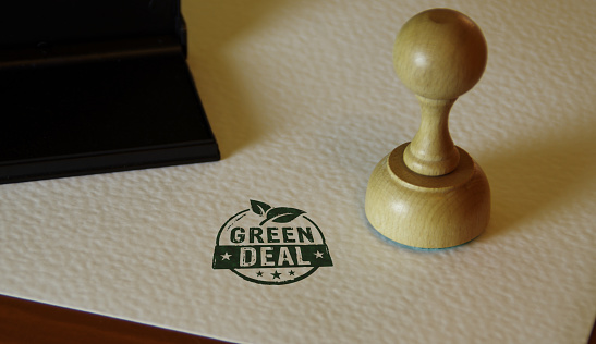 Green Deal stamp and stamping hand. European Fit for 55 and reduce the greenhouse gas emissions concept.