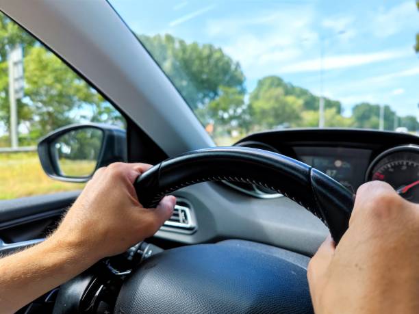 istock White men hands control a car steering wheel while driving on the road 1411209375