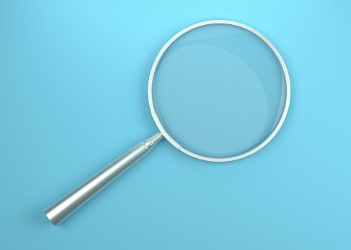 Metal magnifying glass on the Blue background. SEO concept