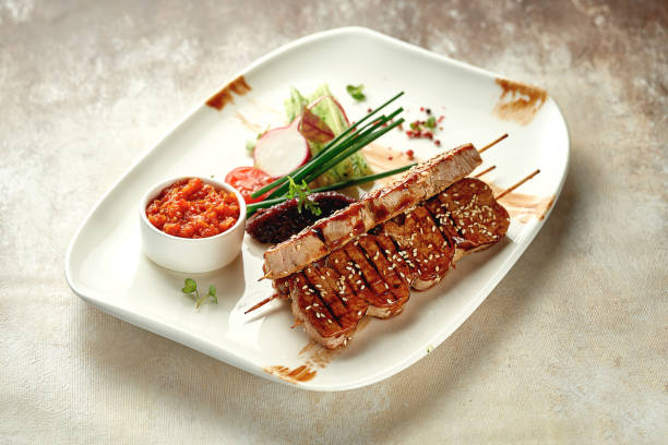 Pork shish kebab with salad and sauce. Close-up selective focus. Grilled meat
