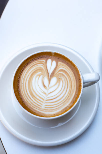 istock white cup of cappuccino with latte art on white table 1411211762