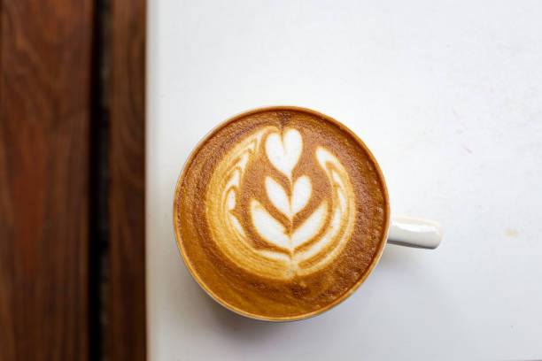 istock white cup of cappuccino with latte art on white table 1411211822