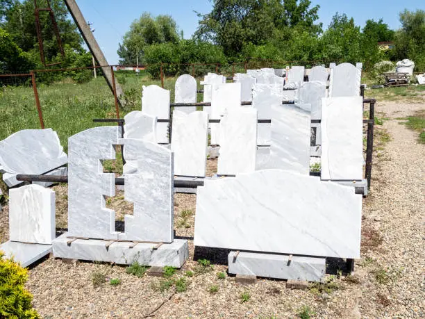 blank stone gravestones and grave slabs in outdoor rural granite workshop on sunny summer day