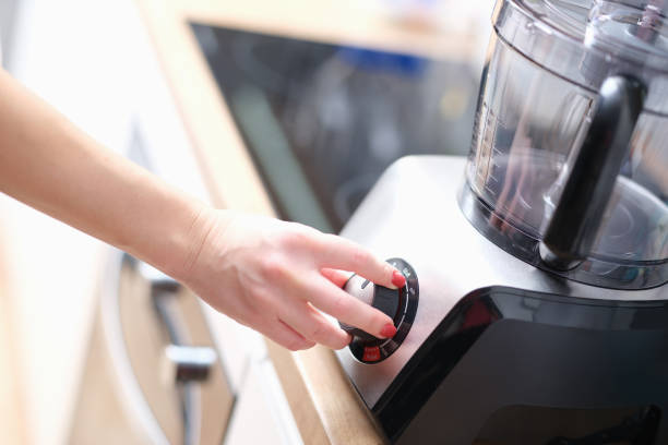 Woman hand presses start of food processor closeup Woman hand presses start of food processor. Turning on mechanism and button to turn on mixer or household kitchen appliances concept electric whisk stock pictures, royalty-free photos & images