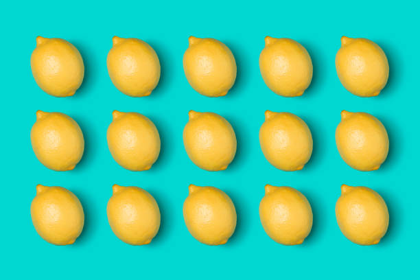 istock Creative layout made of lemon pattern. Flat lay, top view. Food concept. Fruits isolated on blue background. 1411216309