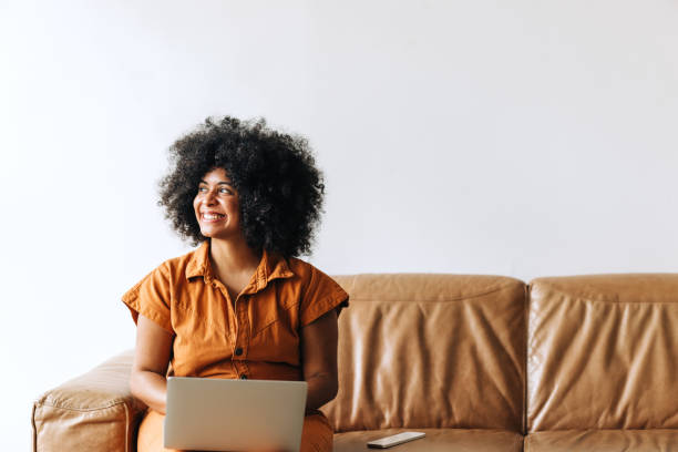 istock Thoughtful black businesswoman smiling while working on a laptop 1411216654