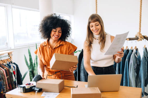 istock Happy clothing store owners preparing parcels for shipping 1411216685