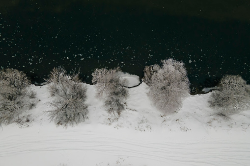 River in winter aerial landscape with shore covered snow, aerial view