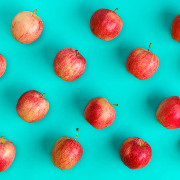 istock Fruit pattern of red apple over blue background. Flat lay, top view. Pop art design, creative summer concept. Food background. . 1411219162