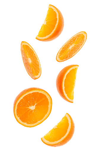 falling fresh orange fruit slices isolated over white background closeup. Flying food concept. Top view. Flat lay. Orange slice in air, without shadow.