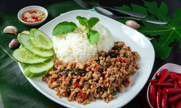 タイの屋台の食べ物、バジルチャーハン、豚ひき肉、目玉焼き、スライスキュウリを黒いテーブルに置きます。 - minced meat beef ground ストックフォトと画像
