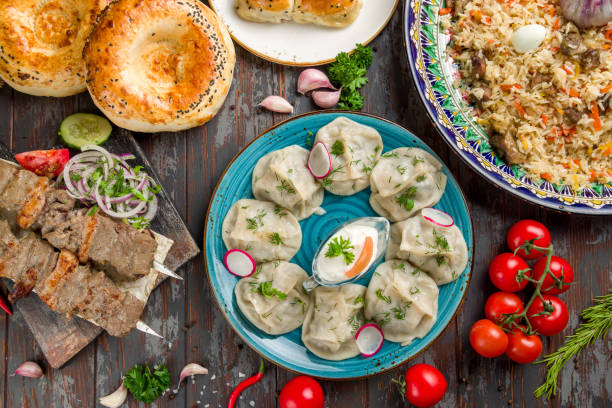 pratos de manti cozinha uzbeque, pilaf, pão, espetos de cordeiro em mesa de madeira velha vista superior - tatar - fotografias e filmes do acervo