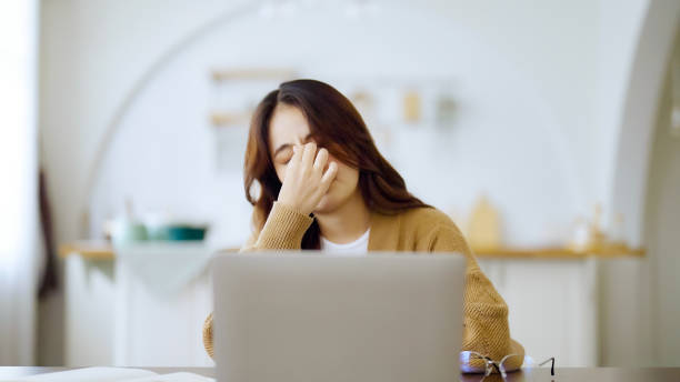 istock Overworked tired young asian woman feeling headache, having eyesight problem after computer laptop work. Stressed adult business woman suffering from fatigue rubbing dry eyes at home 1411220472