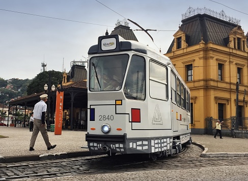 Porto, Portugal - May 30, 2018: View of a typical street in the old town city center with a classic retro tourist tram car and people walking around
