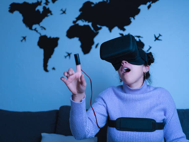 istock Latin woman surprised while wearing virtual reality set at home 1411224648