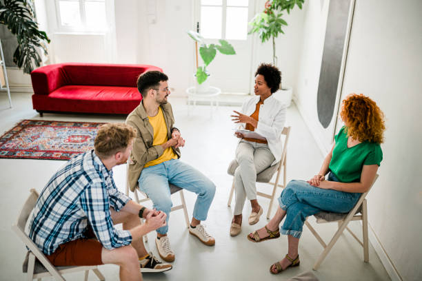 istock Multi-ethnic participants on group therapy having meeting with their psychotherapist at community center. Multiracial people participating in group therapy at mental health center. 1411227874