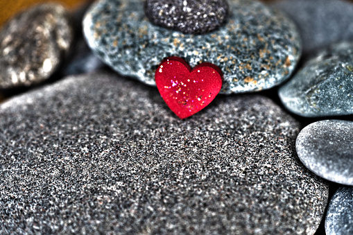 surrealistic red heart on the pebble stone for inspirationand backgrpund