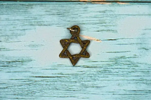 Rustic Star of David pandant on blue wood background for concept symbol of magen david and Israel Country