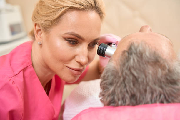 istock Attractive female dermatologist-oncologist performs an examination with a dermatoscope 1411228406