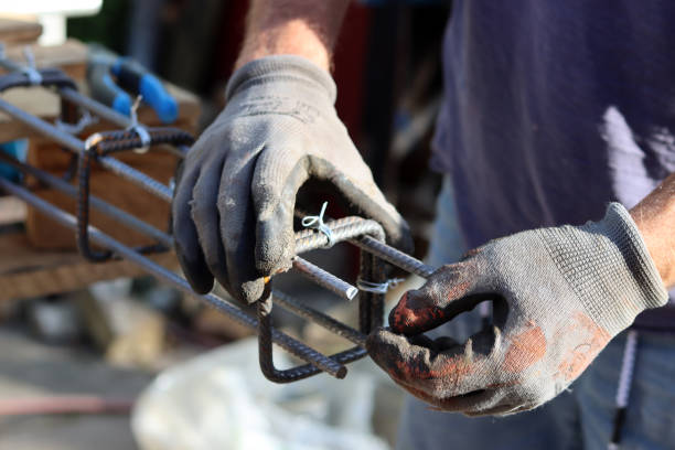 Man working with reinforcement steel Hand holding reinforcement steel. Professional construction worker.  Close up photo of builder's hands in protective gloves. reinforced concrete stock pictures, royalty-free photos & images