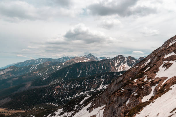 istock Dark mountain ranges partially covered with snow 1411233916