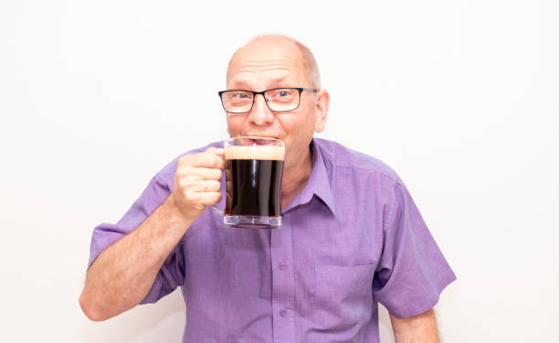 um homem europeu bebe cerveja escura com prazer. - social media fotos - fotografias e filmes do acervo