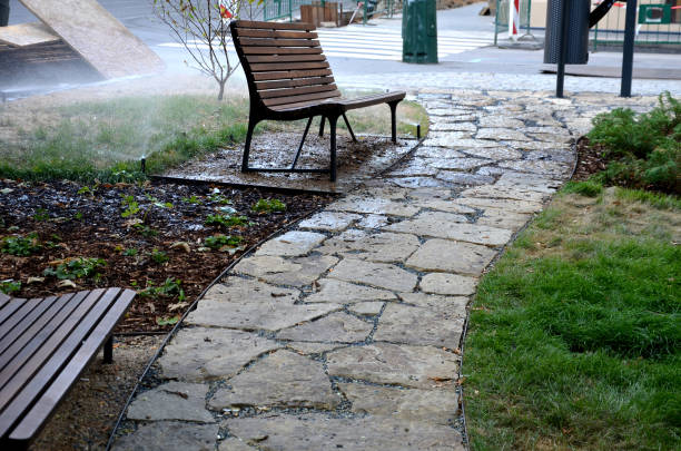 gray stone in a garden with a stone nature path to the arches near the lawns covered with snow. garden walkway made of slate boards side by side in lawn park architecture. ornamental stone, slate, path, upper view, slab, slabs, plastic piedra gris en un jardín con un camino natural de piedra a los arcos cerca de los céspedes cubiertos de nieve. pasarela de jardín hecha de tablas de pizarra una al lado de la otra en la arquitectura del parque de césped. piedra ornamental, pizarra