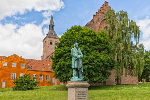 Monument from 1888 for the Danish author Hans Christian Andersen. Odense cathedral in background.