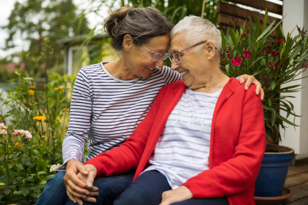 donna anziana con badante in giardino - personale sanitario foto e immagini stock