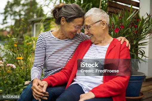 istock Senior woman with caregiver in the garden 1411235353