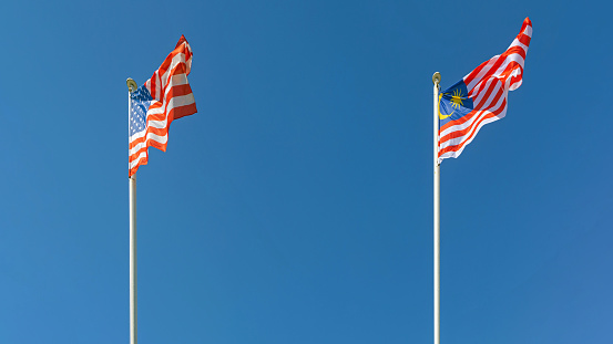 United States of America and Malaysia Flags Together at Sunny Day Blue Sky
