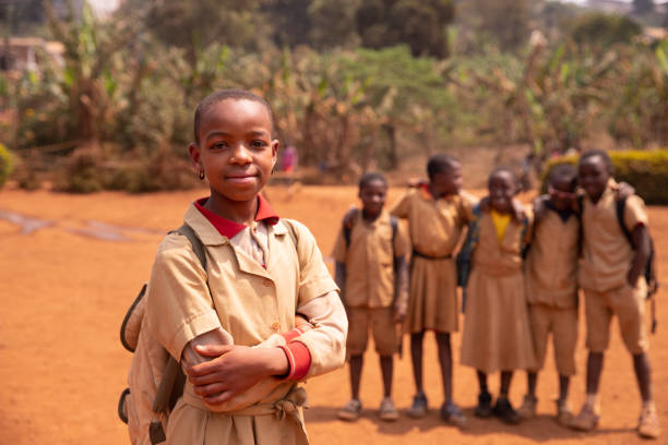 Black schoolgirl in the courtyard standing in the foreground compared to her classmates Black schoolgirl in the courtyard standing in the foreground compared to her classmates. cameroon stock pictures, royalty-free photos & images