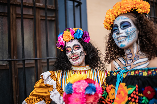Female friends celebrating the day of the dead with makeup and traditional clothing