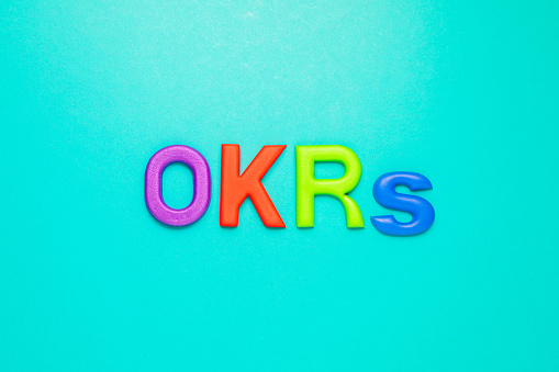 OKRs, Objective Key Results acronym by foam alphabets (learning instrument), on green paper background