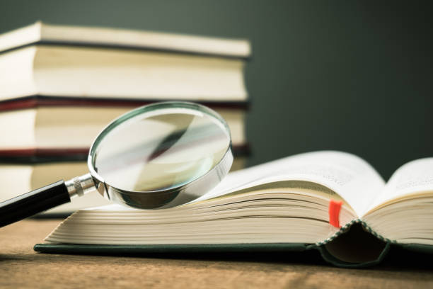 Magnifying glass on the opened book stock photo