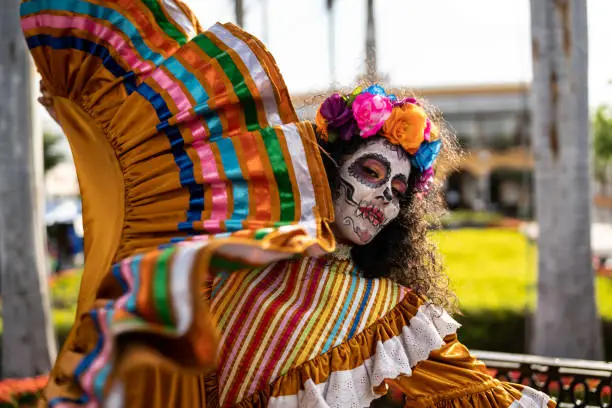 Mid adult woman dancing and celebrating the day of the dead