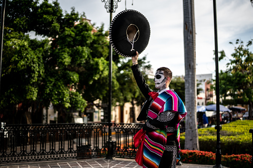 Young man celebrating the day of the dead with makeup and traditional clothing