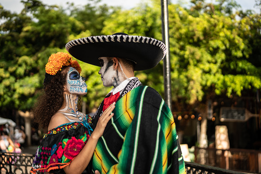 Couple celebrating the day of the dead with makeup and tradicional clothing