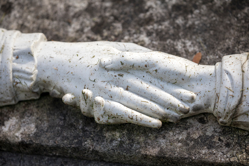 Мужская рука держит большой белый камень на фоне горной реки зимой.