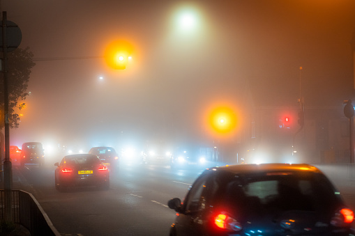 Glasgow, Scotland - Poor visibility at night during winter fog as Crow Road in Glasgow's West End is busy with traffic.