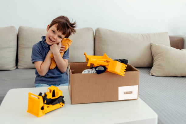 istock Donation concept. Boys hands holding donate box with toys and some clothes. Copy space. 1411245906