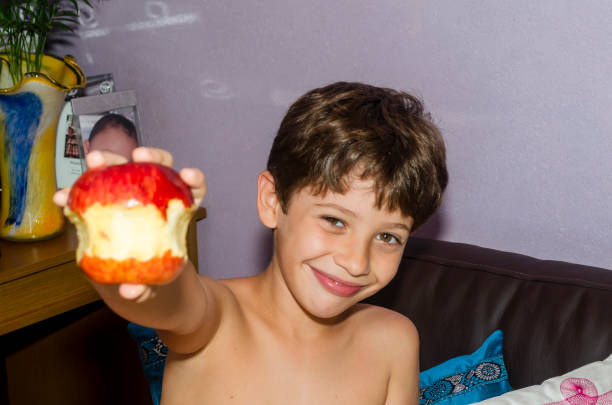 Cute smiling Asian child holding an apple.