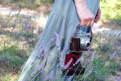 Woman photographing flowers with old analog camera