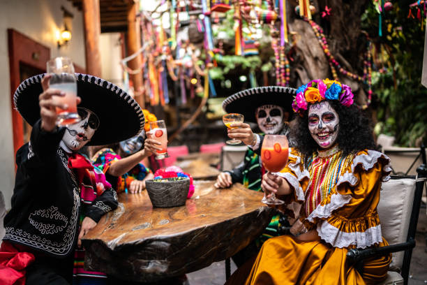 Portrait of friends doing a celebratory toast on the day of the dead at bar Portrait of friends doing a celebratory toast on the day of the dead at bar ritual mask stock pictures, royalty-free photos & images