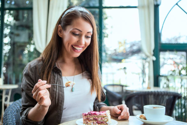 istock Smiling young woman eating dessert 1411248527