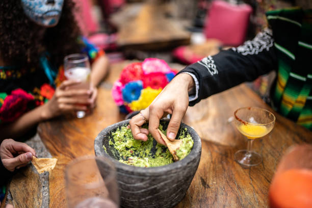 gente comiendo guacamole con nachos el día de muertos en el bar - guacamole avocado mexican culture food fotografías e imágenes de stock