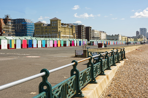 Seafront promenade and beach at Brighton and Hove in East Sussex, England. With unrecognisable people.